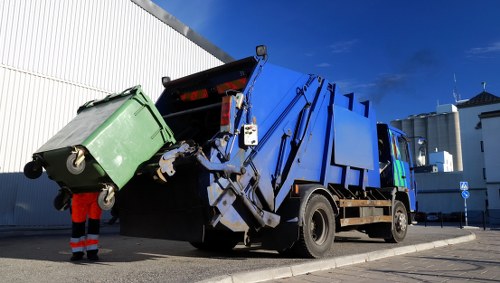 Company van and skip being delivered at a residential driveway